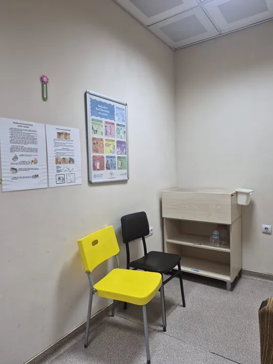 Emzirme bilgilendirme afişleri ve sandalyelerin bulunduğu alan